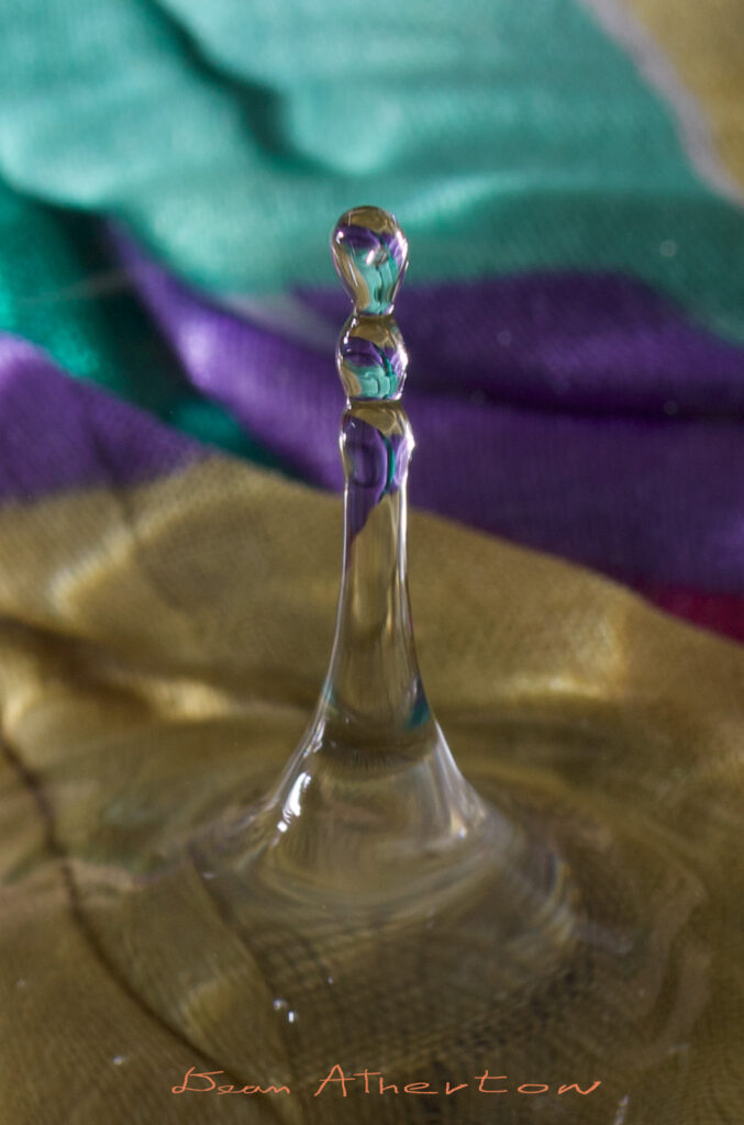 Fast shutter speed captures water drop with colorful background