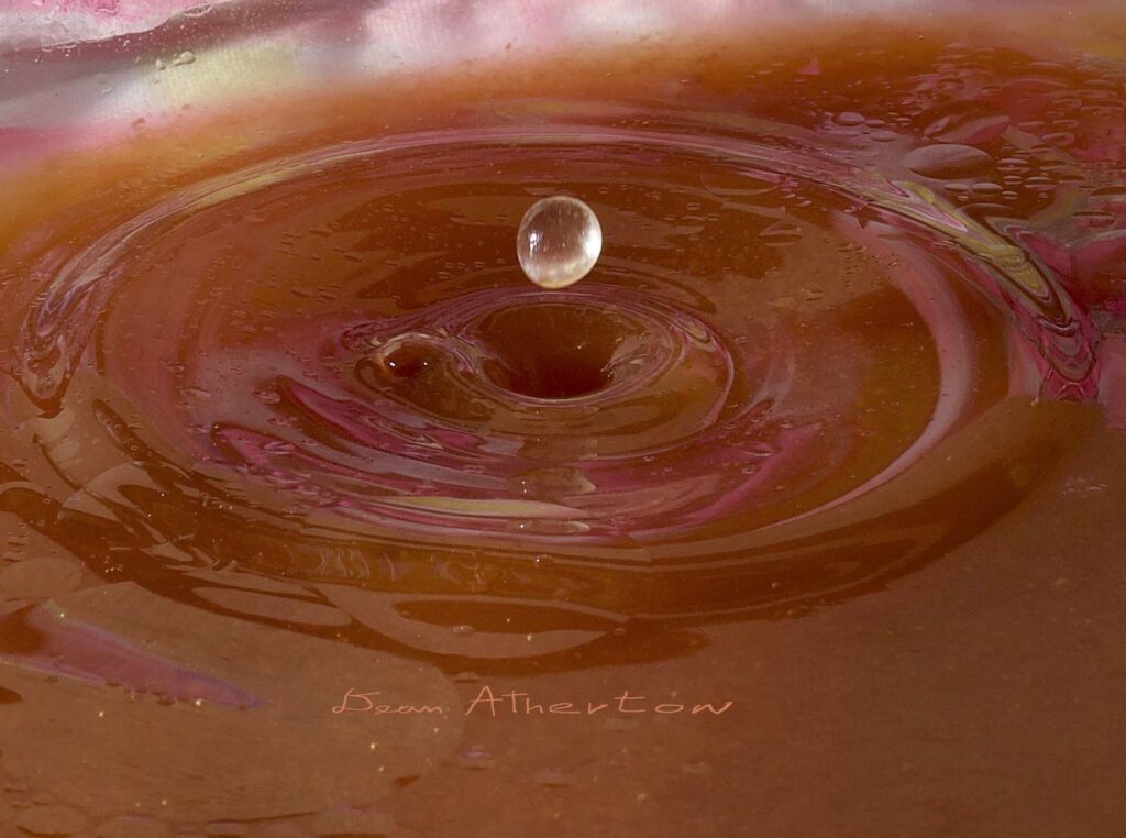 Single water drop shot at fast shutter speed to capture hole created by water from hitting water